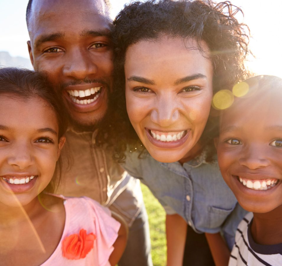 laughing-black-family-outdoors-close-up-back-lit-PPCMZD4.jpg